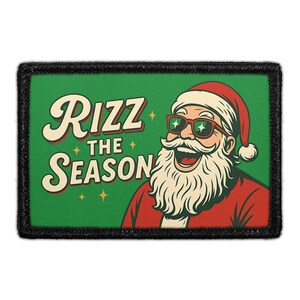 May include: Rectangular patch with a black border and a green background. The patch features a cartoon Santa Claus wearing sunglasses and a red suit. The text "Rizz the Season" is written in a vintage font.
