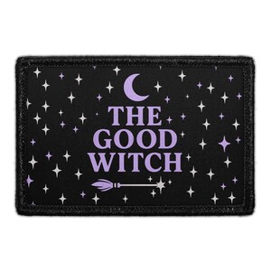 May include: A rectangular black patch with a purple crescent moon, stars, and the words "THE GOOD WITCH" in purple. A white broom is below the text. The patch has a black border.