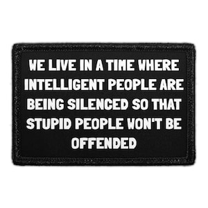 May include: A rectangular black patch with a stitched border featuring the white text: WE LIVE IN A TIME WHERE INTELLIGENT PEOPLE ARE BEING SILENCED SO THAT STUPID PEOPLE WON'T BE OFFENDED. The design is centered on a dark fabric background.