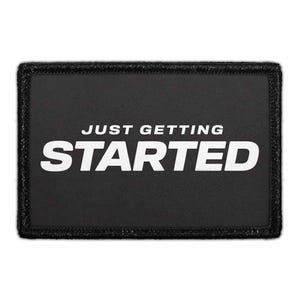 May include: Black rectangular patch with the white text "JUST GETTING STARTED". The patch has a black border. The text is in a bold, sans-serif font.