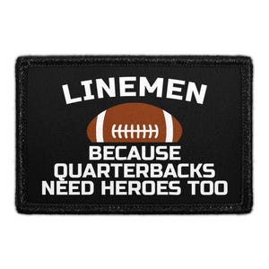May include: A rectangular black patch with a white embroidered border. The text LINEMEN is at the top, a brown football with white laces is in the center, and the text BECAUSE QUARTERBACKS NEED HEROES TOO is at the bottom in white.