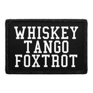 May include: A rectangular black patch with a stitched border featuring the white text WHISKEY TANGO FOXTROT in a bold, block-style font. The design is centered on the fabric surface, presenting a clear, high-contrast graphic element.