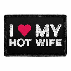 May include: A rectangular black patch with a white distressed font that reads I LOVE MY HOT WIFE. The word LOVE is replaced by a solid red heart symbol. The patch features a black stitched border and a clean, flat design suitable for attachment.