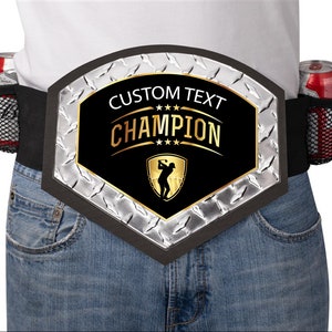 May include: A black and silver championship belt with a gold golfer silhouette and the text "CUSTOM TEXT CHAMPION" on a black background. The belt has a black elastic strap with two mesh drink holders on each side.