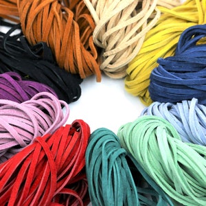 May include: A variety of colors of leather cord, including red, green, blue, purple, and brown. The cords are arranged in a circle.