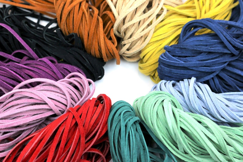 May include: A variety of colors of leather cord, including red, green, blue, purple, and brown. The cords are arranged in a circle.