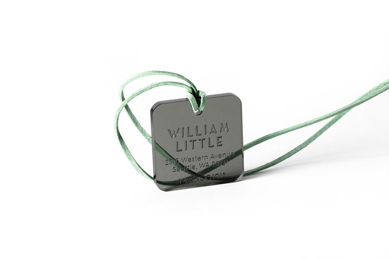 May include: A black square tag with a green cord. The tag has the text "WILLIAM LITTLE" and an address in Seattle, Washington.
