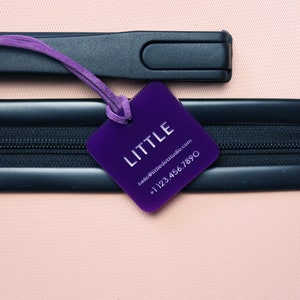 May include: Purple luggage tag with the word "LITTLE" and contact information: "hello@littledotstudio.com +1 123 456 7890"