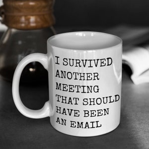 May include: White ceramic coffee mug with black text that reads "I survived another meeting that should have been an email".