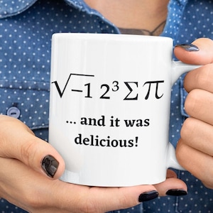 May include: White ceramic mug with black text that reads "√-1 2³ Σπ ... and it was delicious!"