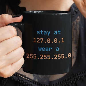 May include: Black coffee mug with the text "stay at 127.0.0.1 wear a 255.255.255.0" in blue and orange text.