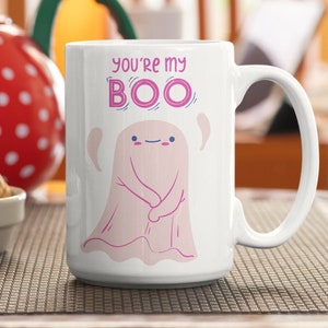 May include: White ceramic coffee mug with a pink ghost illustration and the text "You're my BOO".
