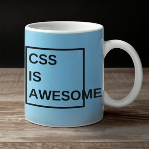 Puede incluir: Una taza de cerámica azul claro con un borde negro alrededor del texto "CSS is AWESOME" impreso en la parte delantera.