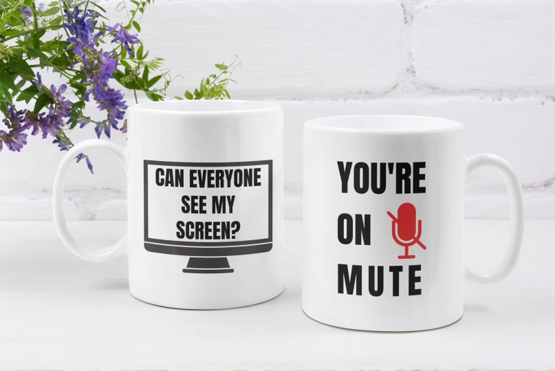 Puede incluir: Dos tazas de caf&eacute; blancas con texto negro y gr&aacute;ficos. La taza de la izquierda dice "Can everyone see my screen?" con un gr&aacute;fico de monitor de computadora negro. La taza de la derecha dice "You're on mute" con un gr&aacute;fico de micr&oacute;fono negro con una barra diagonal roja.