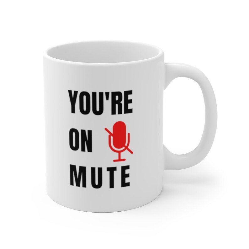 Puede incluir: Taza de caf&eacute; de cer&aacute;mica blanca con texto negro que dice "YOU'RE ON MUTE" con un icono de micr&oacute;fono rojo con una l&iacute;nea diagonal.