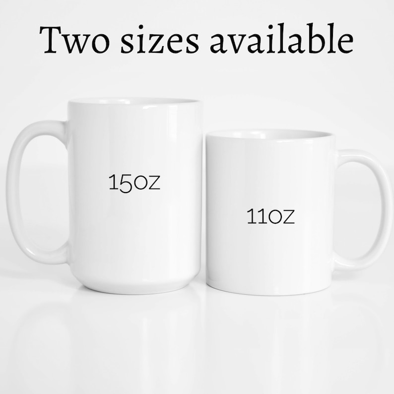 Op de afbeelding: Twee witte keramische mokken, een van 15 oz en een van 11 oz, naast elkaar op een wit oppervlak.