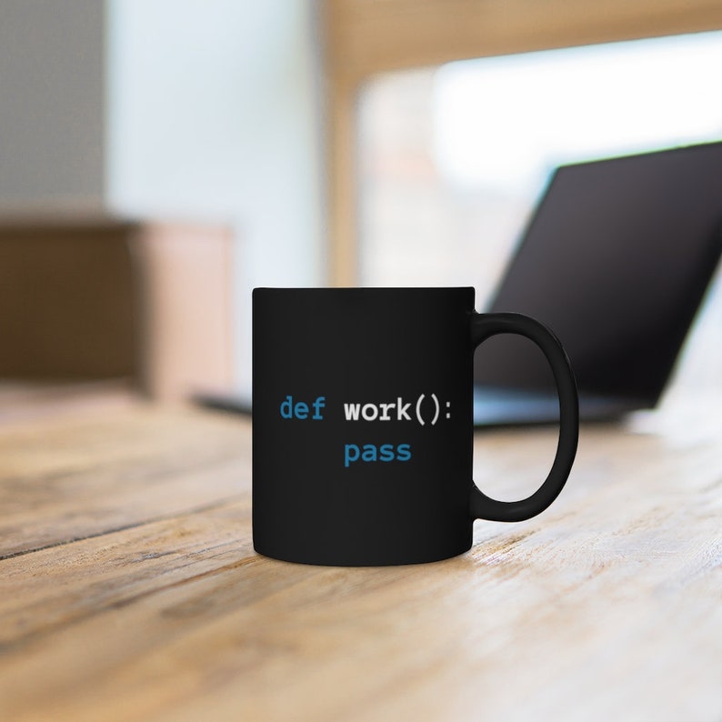 Pu&ograve; includere: Tazza da caff&egrave; nera con il testo "def work(): pass" in blu su una superficie di legno.