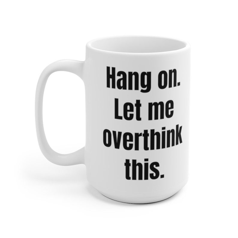 K&ouml;nnte beinhalten: Wei&szlig;e Keramik-Kaffeetasse mit schwarzem Text, der "Hang on. Let me overthink this." lautet.
