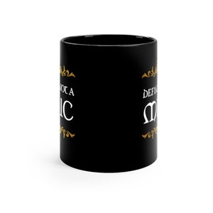 May include: Black ceramic coffee mug with a gold design and the text "Not a Basic" on the left side and "Definitely Magic" on the right side.