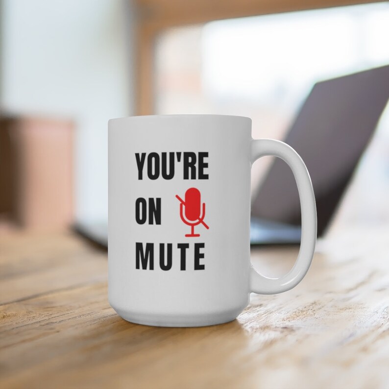 Puede incluir: Taza de caf&eacute; de cer&aacute;mica blanca con texto negro que dice "YOU'RE ON MUTE" y un icono de micr&oacute;fono rojo con una l&iacute;nea diagonal.