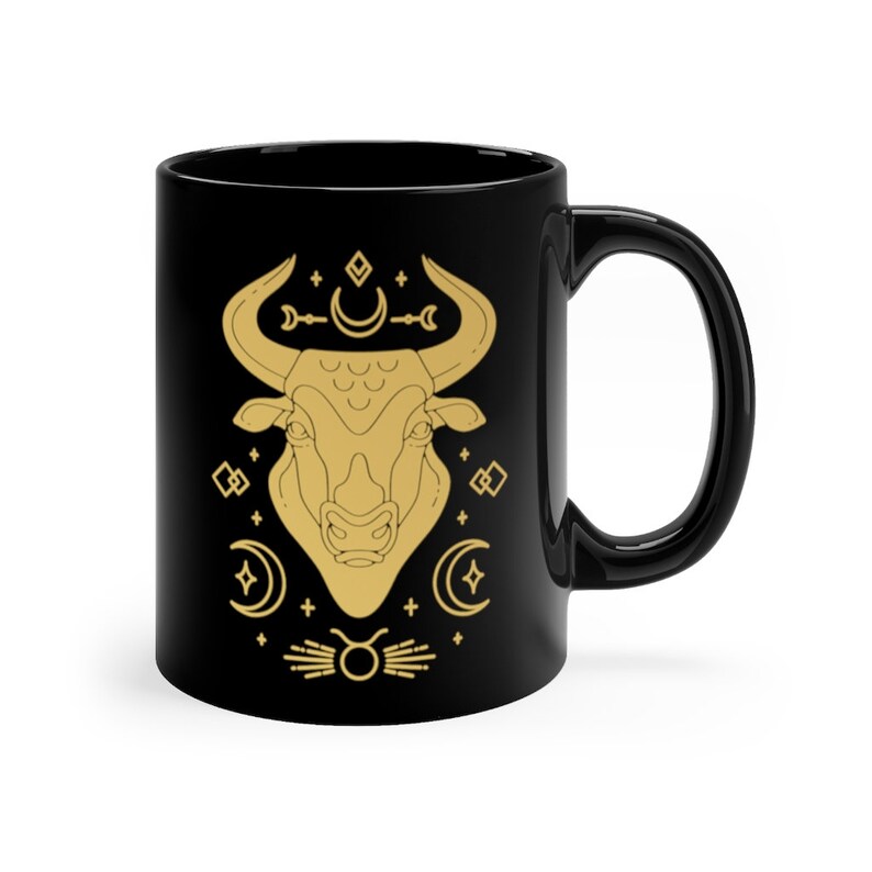 May include: Black ceramic mug with a gold outline of a bull's head and astrological symbols.