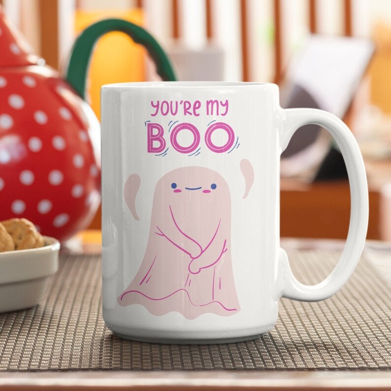 May include: White ceramic coffee mug with a pink ghost illustration and the text "You're my BOO".