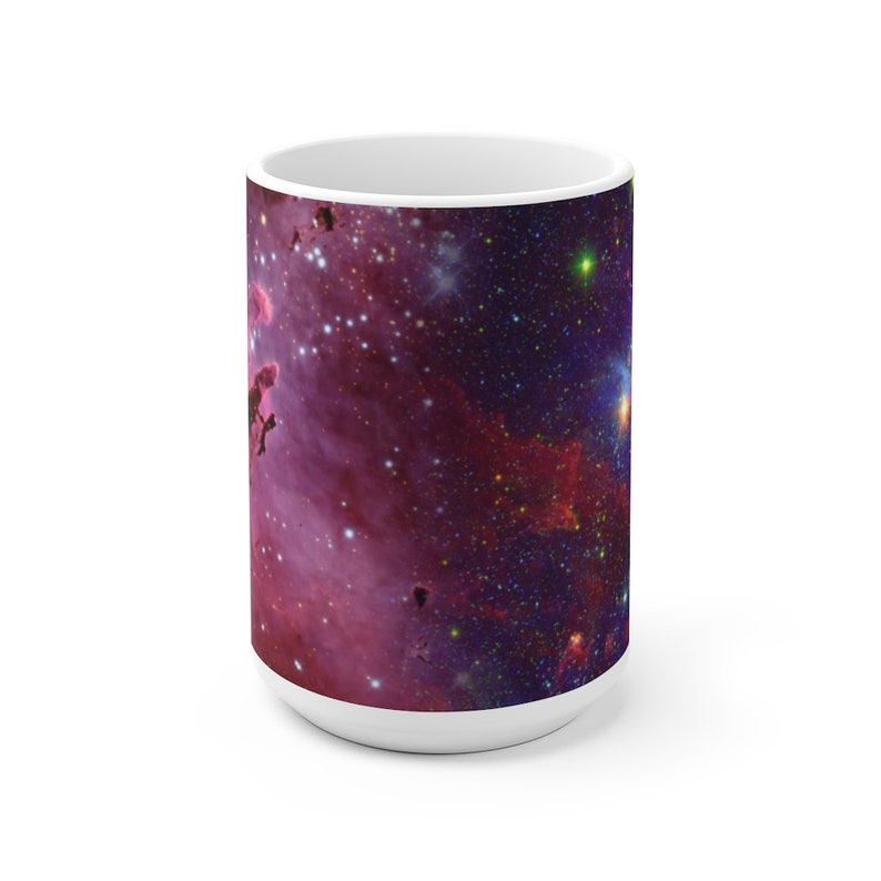 May include: White ceramic mug with a colorful nebula image. The image features a pink and purple nebula with a scattering of stars.
