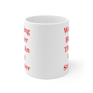 May include: White ceramic mug with red text that reads "Working harder than a super hero" on the left side and "Work hard, have fun, then do it again" on the right side.