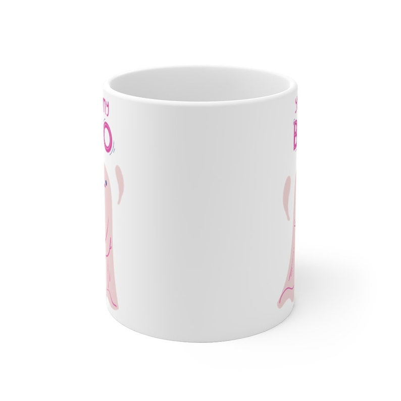 May include: White ceramic mug with a pink ghost illustration and the text "Spooky Boo" in pink lettering.