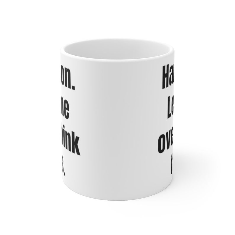 K&ouml;nnte beinhalten: Eine wei&szlig;e Keramik-Kaffeetasse mit schwarzem Text, der "Hang in there. Let's overthink this." lautet.