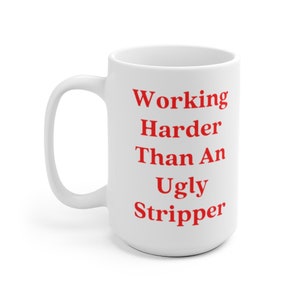 May include: White ceramic coffee mug with the text "Working Harder Than An Ugly Stripper" printed in red.