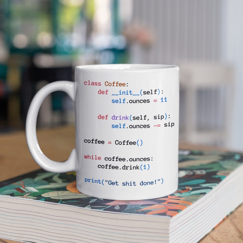 May include: White ceramic coffee mug featuring a humorous Python code printed on it. The code defines a "Coffee" class with a "drink" method that reduces the number of ounces of coffee in the mug. The code concludes with the phrase "Get shit done!"