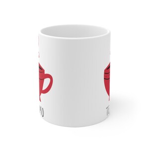 May include: White ceramic mug with a red teacup graphic on each side. The text "Te Amo" is on the left side and "Te Quiero" is on the right side.