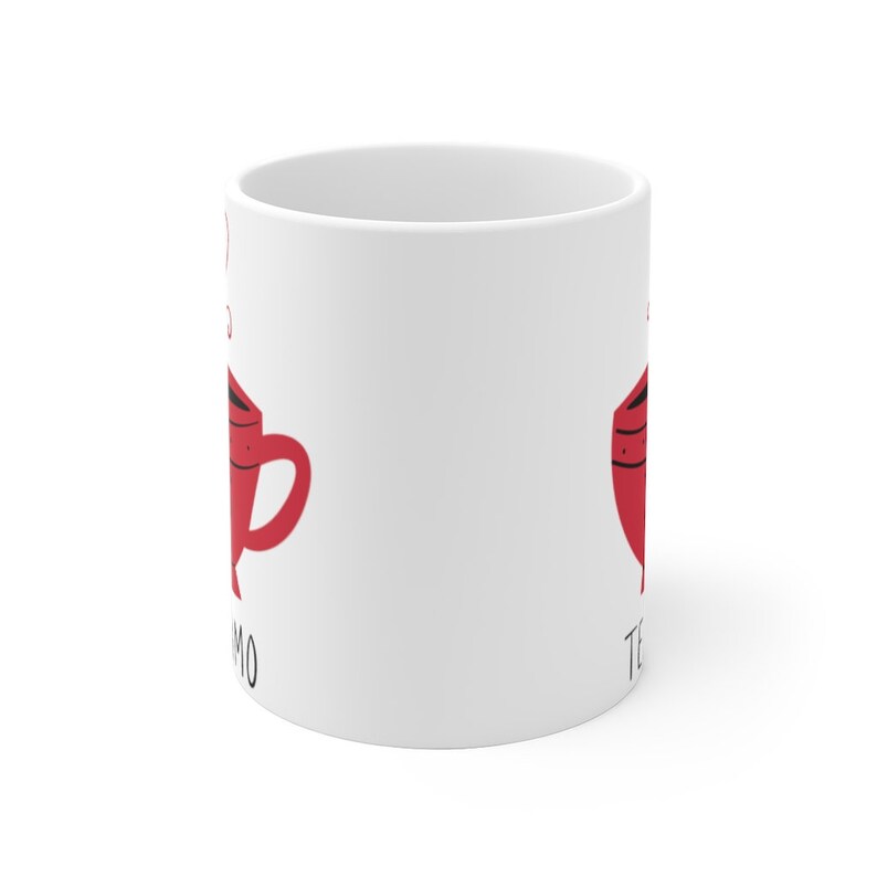 May include: White ceramic mug with a red teacup graphic on each side. The text "Te Amo" is on the left side and "Te Quiero" is on the right side.