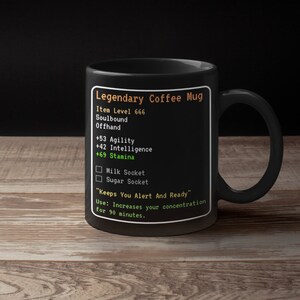 May include: Black coffee mug with a video game-style design. It reads "Legendary Coffee Mug", "Item Level 666", "Soulbound", "Offhand", "+53 Agility", "+42 Intelligence", "+69 Stamina", "Milk Socket", "Sugar Socket", "Keeps You Alert And Ready", "Use: Increases your concentration for 90 minutes."