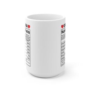 Op de afbeelding: Witte keramische mok met een rood hart en de tekst "Grandma Facts" en "Grandma Nutrition Facts" aan beide kanten. De tekst somt verschillende eigenschappen van een oma op, zoals "Onvoorwaardelijke liefde", "Eindeloze geduld" en "Geluk".