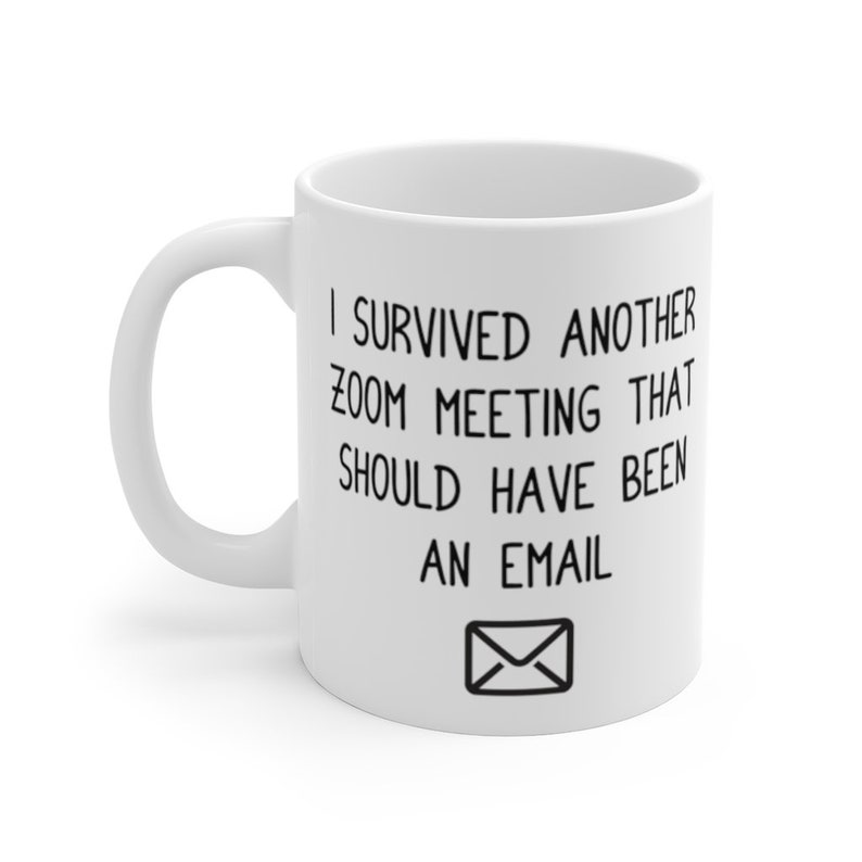 May include: White ceramic coffee mug with black text that reads "I survived another zoom meeting that should have been an email" with an envelope icon.
