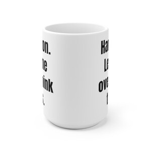 K&ouml;nnte beinhalten: Wei&szlig;e Keramik-Kaffeetasse mit schwarzem Text, der "Hang in there. Let's overthink this." lautet.