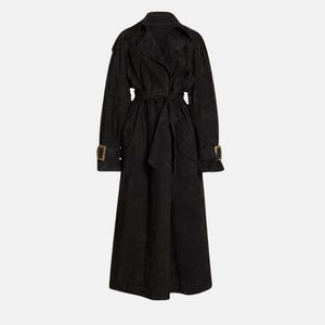 May include: A long black trench coat featuring a wide notched collar, long sleeves with buckled cuffs, and a matching tie belt at the waist. The coat has a textured finish and falls to a midi length, providing a structured and classic silhouette.