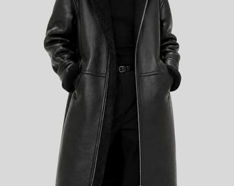 May include: A long black coat featuring a smooth outer finish and a thick black faux fur lining. The coat has a wide collar, a full-length front zipper, long sleeves with fur-lined cuffs, and adjustable buckle straps at the lower side hems.