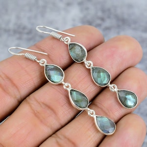 May include: A pair of silver dangle earrings with five teardrop-shaped labradorite gemstones. The earrings have a silver hook closure.