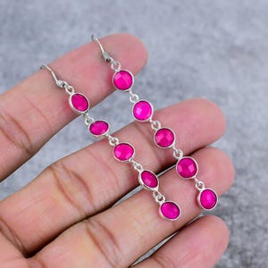 Può includere: Un paio di lunghi orecchini pendenti in argento con perline di pietre preziose rosa. Gli orecchini hanno un totale di sei perline su ogni orecchino.
