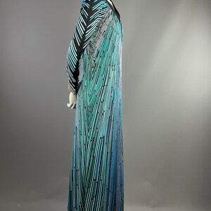 Peut inclure: Une longue robe maxi &agrave; motif noir et bleu avec un d&eacute;collet&eacute; en V et des manches longues.