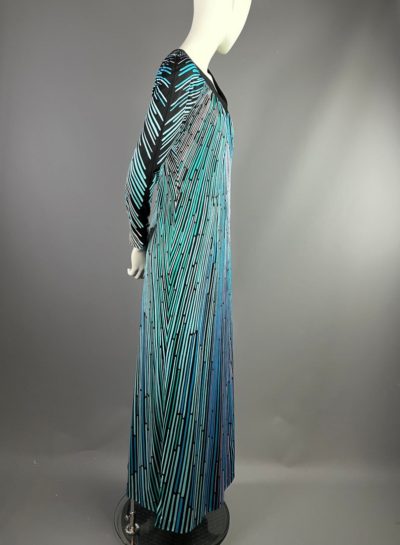 Peut inclure: Une longue robe maxi &agrave; motif noir et bleu avec un d&eacute;collet&eacute; en V et des manches longues.