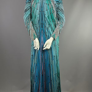 Peut inclure: Une longue robe maxi &agrave; rayures noires, bleues, vertes et roses avec un d&eacute;collet&eacute; en V et des manches longues.