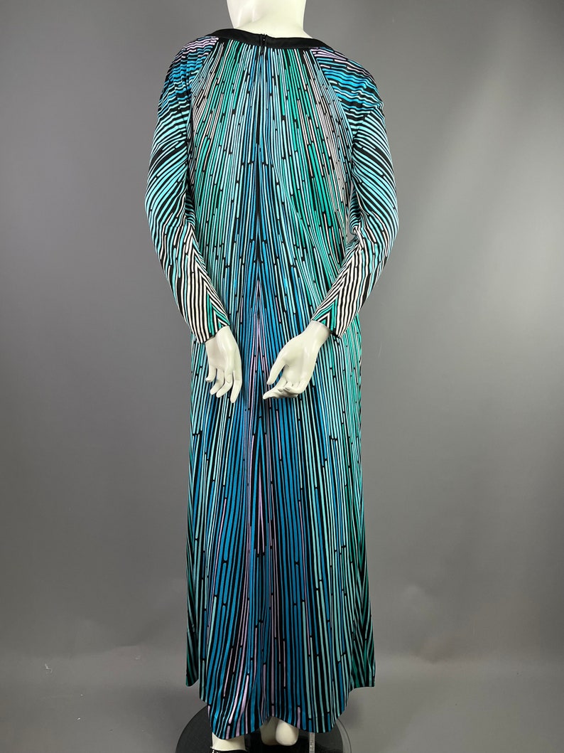 Peut inclure: Une longue robe maxi &agrave; rayures noires, bleues, vertes et roses avec un d&eacute;collet&eacute; en V et des manches longues.