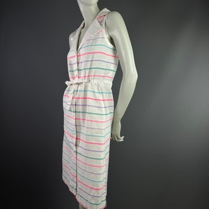 May include: A white sleeveless dress with a button-up front and a tie belt. The dress has horizontal stripes in pink, green, and purple.