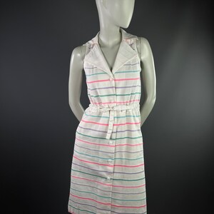 May include: A white sleeveless dress with a striped pattern in pink, green, and purple. The dress has a collared neckline, button closure, and a tie at the waist.
