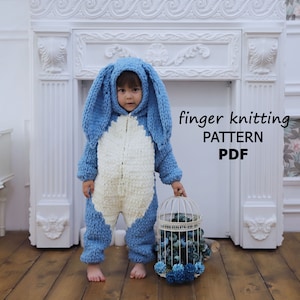 May include: A blue and white knitted bunny costume for a baby. The costume has a hood with bunny ears and a zipper down the front. The text "finger knitting PATTERN PDF" is visible in the image.