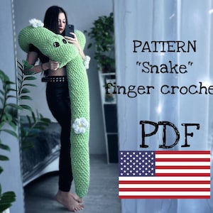 Może przedstawiać: Wzór na szydełku na zielonego węża z białymi kwiatami, zatytułowany "PATTERN "Snake" finger crochet PDF". Wzór jest dostępny jako plik do pobrania.